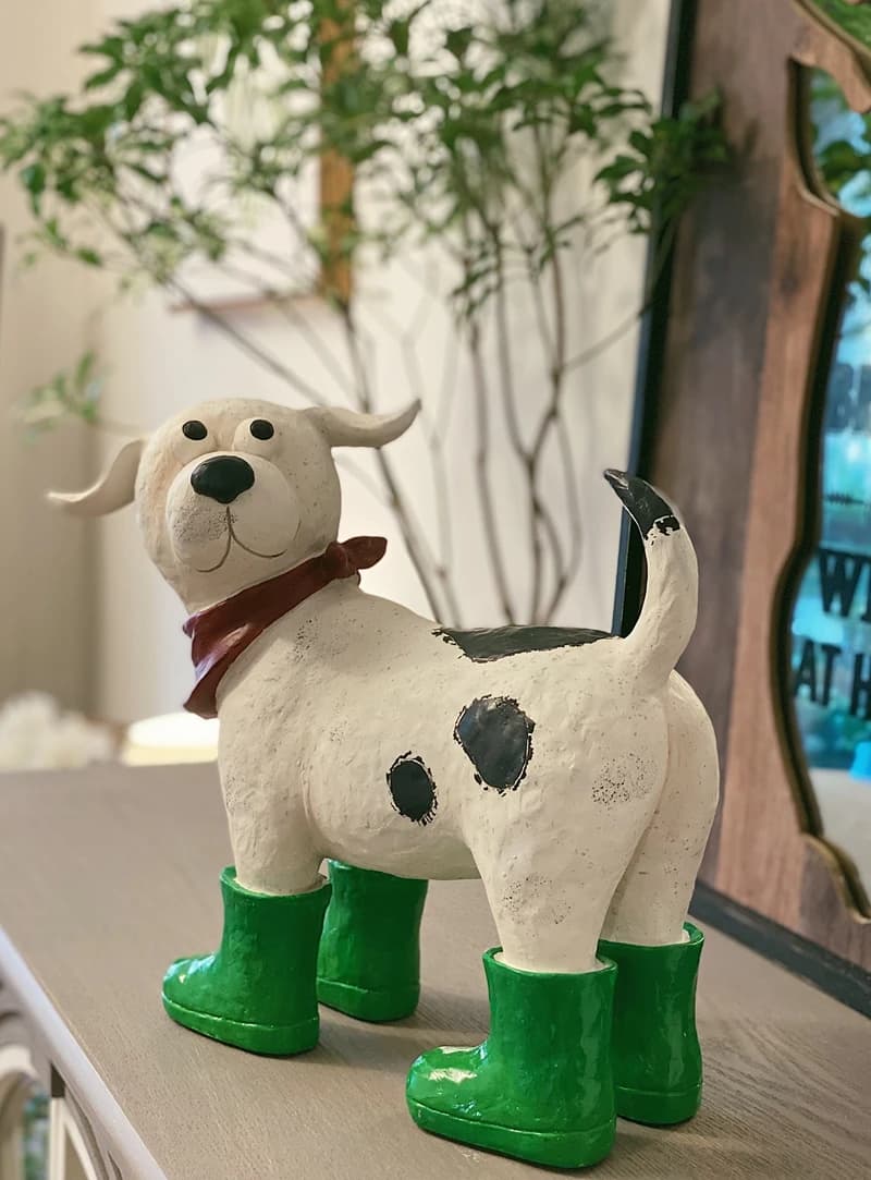 A Cartoon Resin Decorative Item for A Courtyard Garden with White and Black Dots Wearing Green Shoes and A Red Scarf