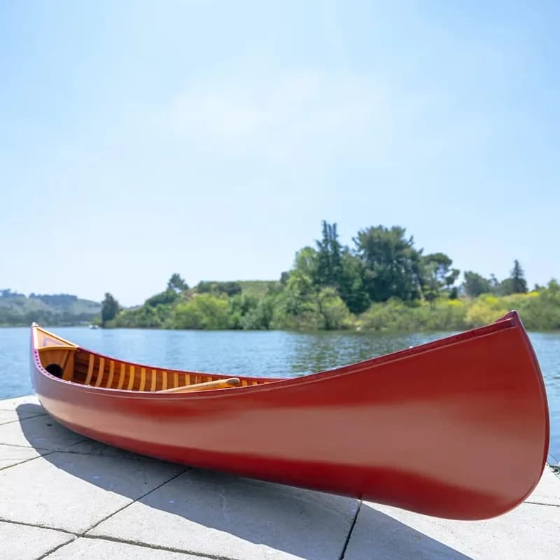 Red cedar canoe with curved bow and paddle for lake fishing