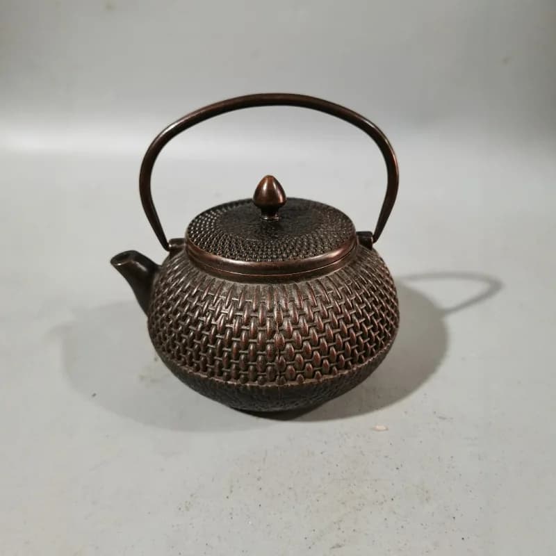 Antique and vintage market items: aged copper and brass wine flask with handle, teapot, and copper kettle as decorative pieces