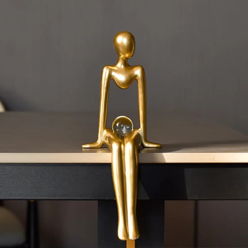 Simple little golden man holding a ball and listening to music, gold abstract figure sculpture home decoration office